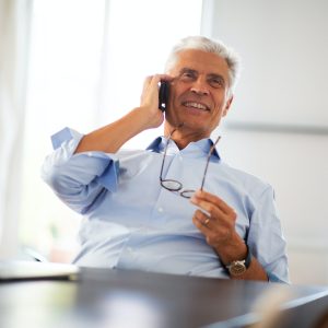 happy businessman talking with cellphone at office